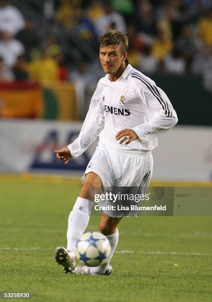 David Beckham of the Real Madrid dribbles against the defense of the Los Angeles Galaxy during the game at the Home Depot Center on July 18, 2005 in...