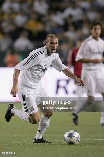 Zinedine Zidane of the Real Madrid dribbles against the defense of the Los Angeles Galaxy during the game at the Home Depot Center on July 18, 2005...