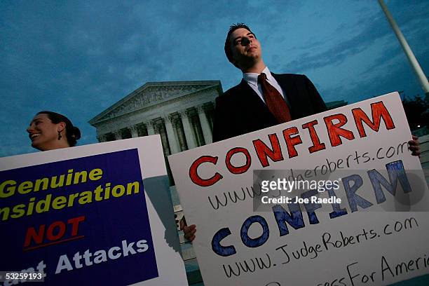 Chara McMichael and Joe Brennan hold signs as they and other activists from Progress for America gather in front of the Supreme Court July 19 , 2005...