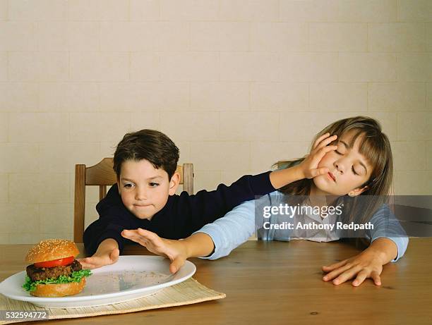 siblings fighting over hamburger - rivalry stockfoto's en -beelden