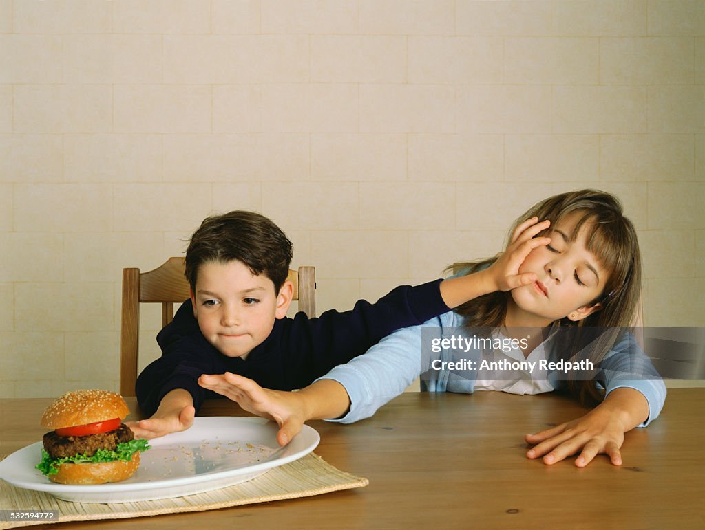 Siblings Fighting over Hamburger