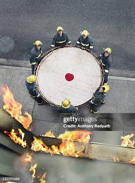 firefighters holding safety net - safety net stock pictures, royalty-free photos & images