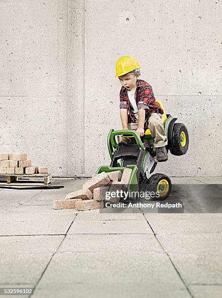little boy on a toy shovel dumping a load of bricks - construction mistake stock pictures, royalty-free photos & images
