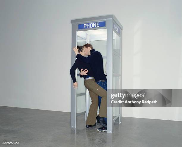 young couple kissing in phone booth - anthony peck stock pictures, royalty-free photos & images