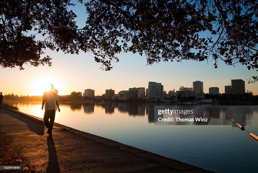 Man walking at sunset along lake