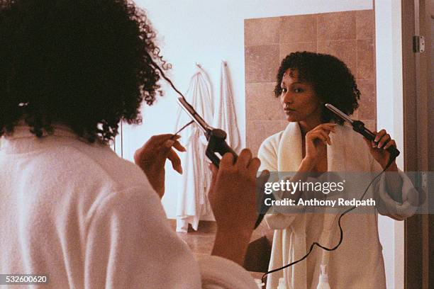 woman in bathroom curling hair - hair curlers stock-fotos und bilder