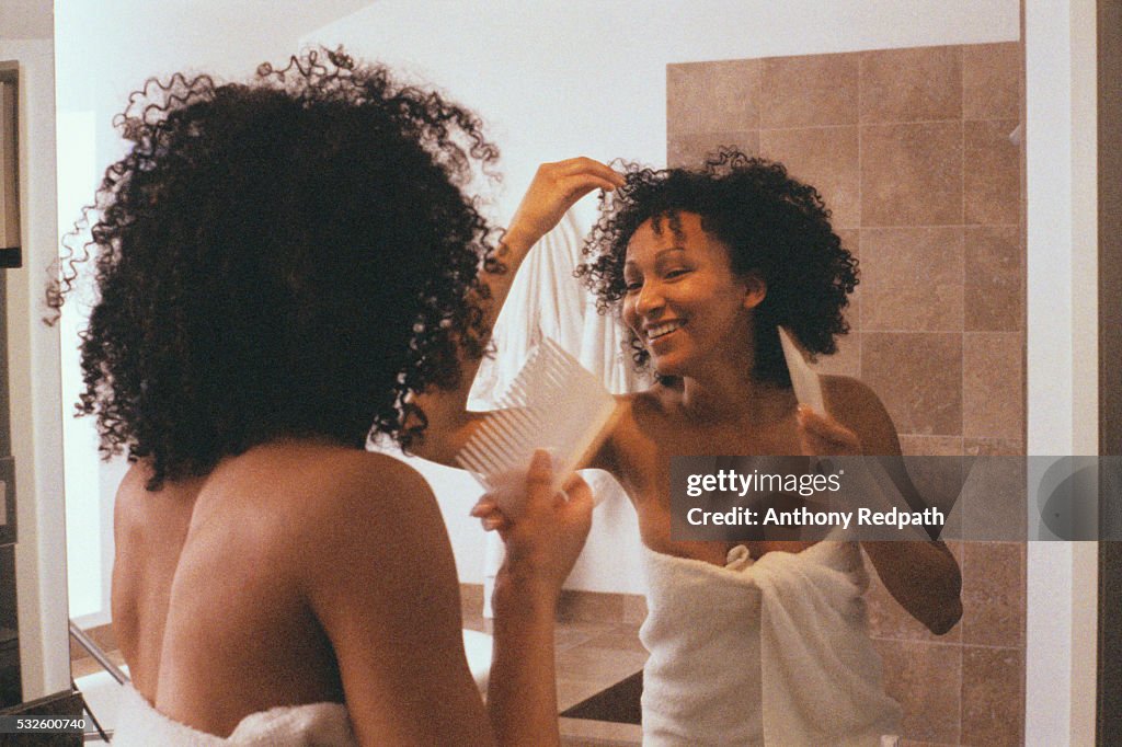 Woman in Bathroom Combing Hair