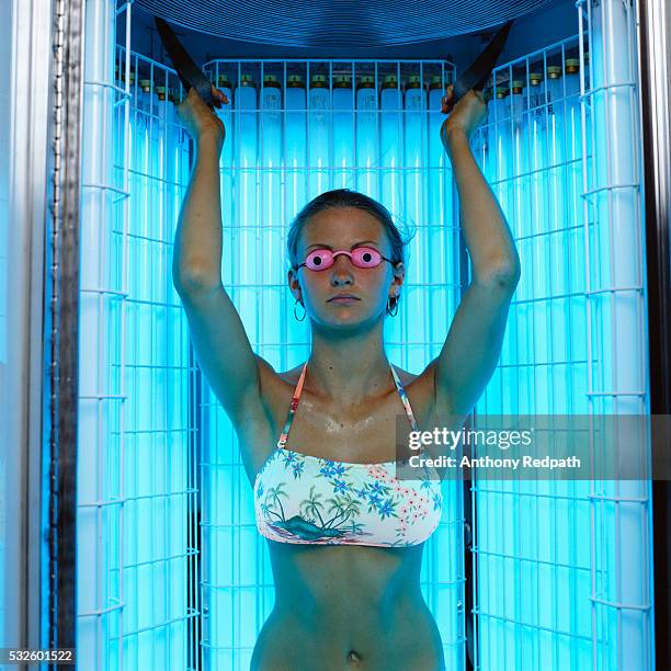 woman standing in tanning booth - tanning bed stock pictures, royalty-free photos & images