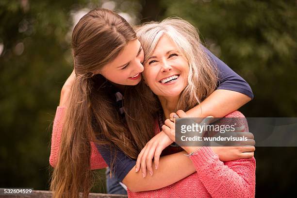 daughter surprises mother with a hug from behind - surprised mum stock pictures, royalty-free photos & images