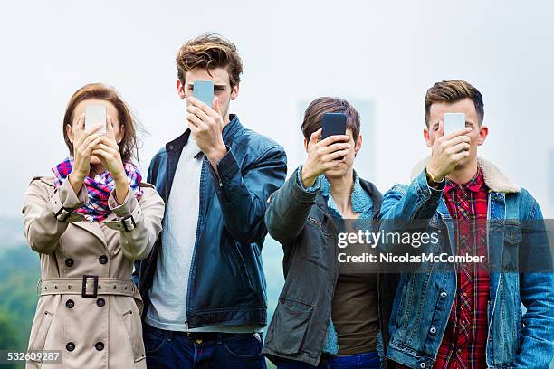 four friends shooting selfies on their mobile phones - last day bildbanksfoton och bilder