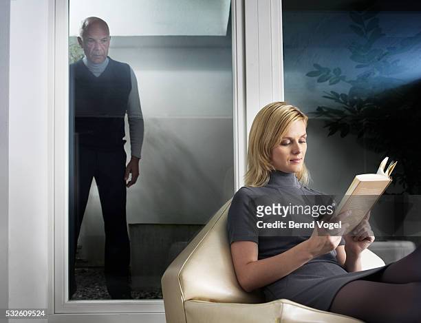senior man watching young woman reading - molestatore foto e immagini stock