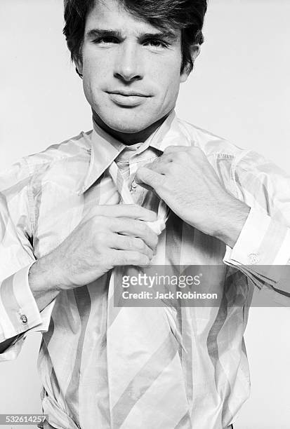Portrait series of actor Warren Beatty as he knots his necktie, late 1960s or early 1970s.