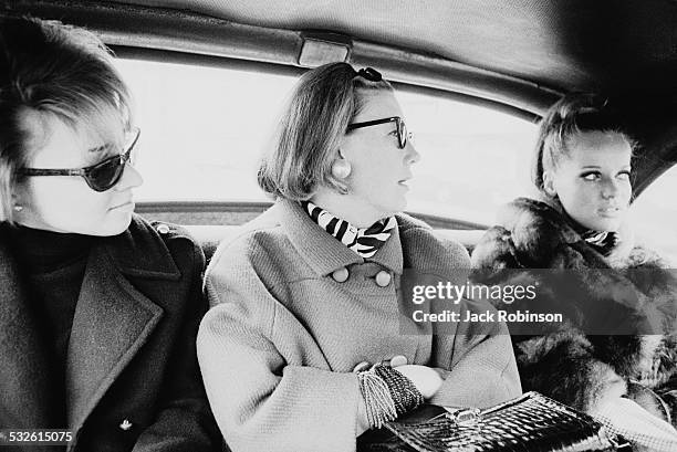 Vogue magazine style editor Carrie Donovan rides in a car with the model Veruschka , 1966. The figure on the left is unidentified.