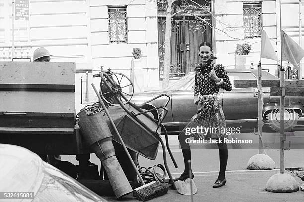 Designer Gloria Vanderbilt stands next to a construction site on a street, New York, New York, 20th century.