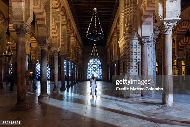 woman walking inside the mezquita, cordoba, spain - córdoba spanien bildbanksfoton och bilder