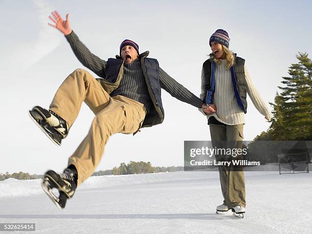 couple skating outside, man falling - dropped ice block stock pictures, royalty-free photos & images