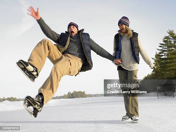 couple skating outside, man falling - couple skating stock pictures, royalty-free photos & images