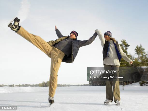 couple skating outside, man falling - ice skater couple stock pictures, royalty-free photos & images