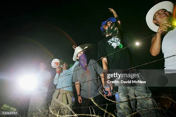 Migrant activists protesting nightly patrols by citizen volunteers who search for people crossing US-Mexico border use powerful spot lights and loud...