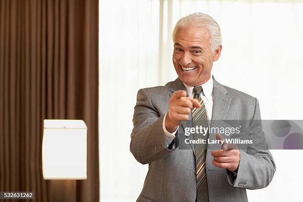 businessman pointing - estereotipo fotografías e imágenes de stock