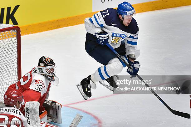 Finland's forward Leo Komarov jumps in front of Denmark's goalie Sebastian Dahm during the quarterfinal game Finland vs Denmark at the 2016 IIHF Ice...