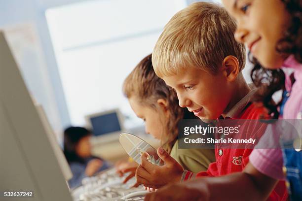 boy at computer with cd - kids rom stock pictures, royalty-free photos & images