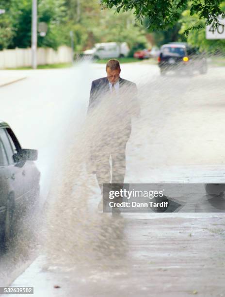 car splashing water on businessman - car splashing stock pictures, royalty-free photos & images