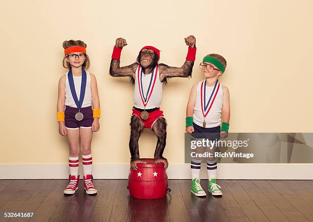 chimpanzee champion with gold medal and young children - eccentric stock pictures, royalty-free photos & images