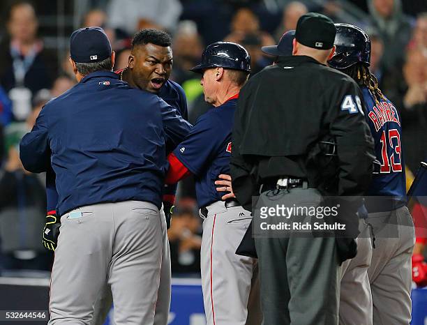 David Ortiz of the Boston Red Sox is restrained by a coach after being thrown out of the game by home plate umpire Ron Kulpa in the ninth inning...