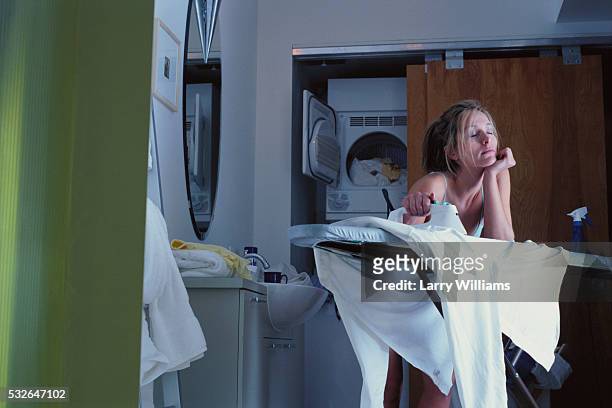 tired woman doing domestic chores - ironing board imagens e fotografias de stock