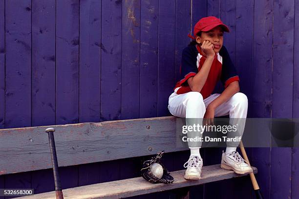 softball player waiting at bench - softball sport stock pictures, royalty-free photos & images