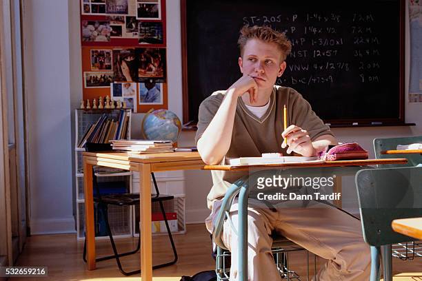 pensive high school boy staying after class - archival classroom stock pictures, royalty-free photos & images