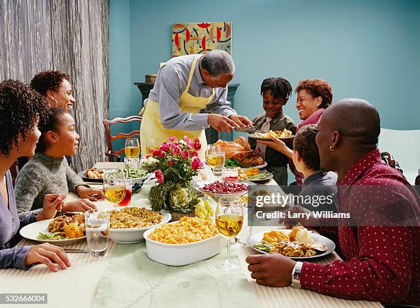 family eating thanksgiving dinner - thanksgiving indulgence stock pictures, royalty-free photos & images