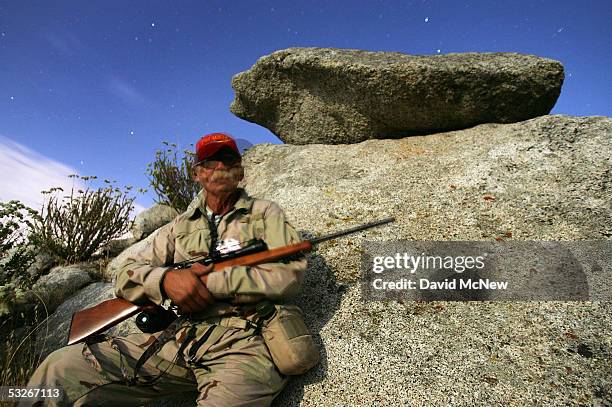 Volunteer Robert Crooks is illuminated by the moon and stars as he holds a rifle, which he will use only in self-defense, at his post on the...