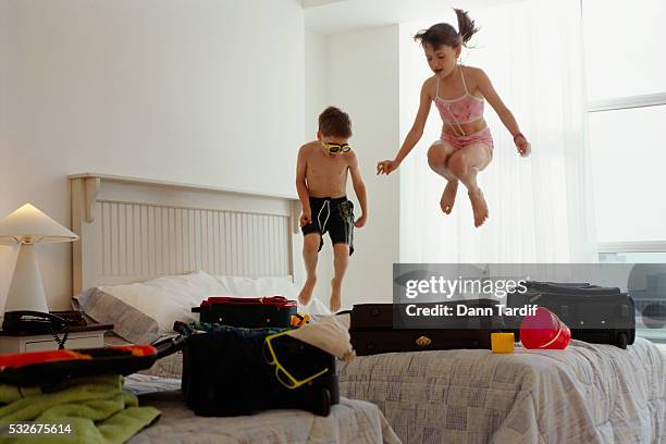 children jumping on bed - family holidays hotel stock pictures, royalty-free photos & images