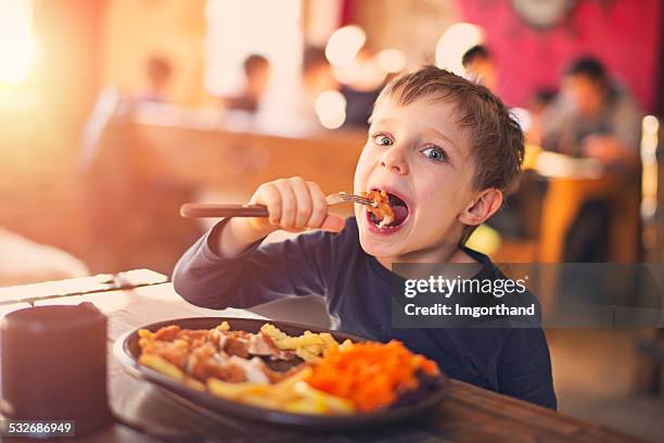 kleine junge genießen sie ein abendessen im restaurant - plate chicken stock-fotos und bilder