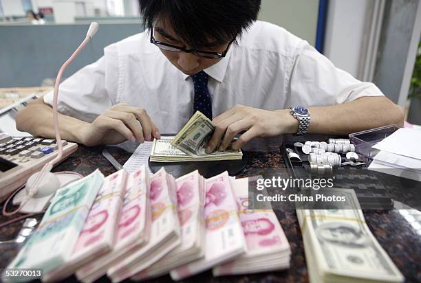 Clerk counts stacks of Chinese yuan and U.S. Dollars at a bank July 22, 2005 in Shanghai, China. The People's Bank of China, the central bank,...