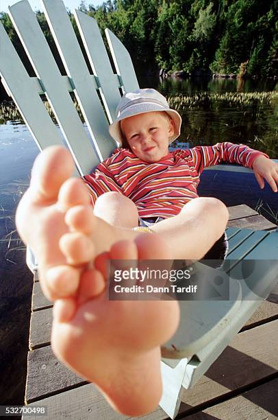 feet of a relaxed boy - adirondack chair closeup stock pictures, royalty-free photos & images