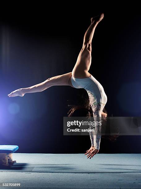 young woman doing gymnastics jump - 女子体操 個照片及圖片檔