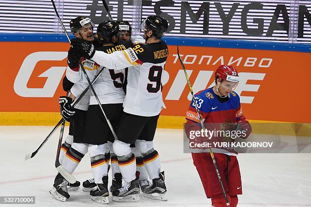 Germany's players celebrate a goal as Russia's defender Alexei Marchenko skates away during the quarterfinal game Russia vs Germany at the 2016 IIHF...