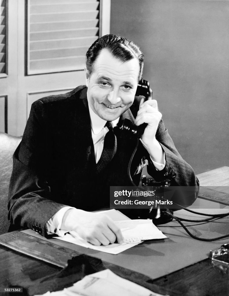 Businessman using telephone at his desk