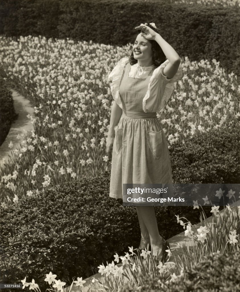 Woman standing among spring daffodils