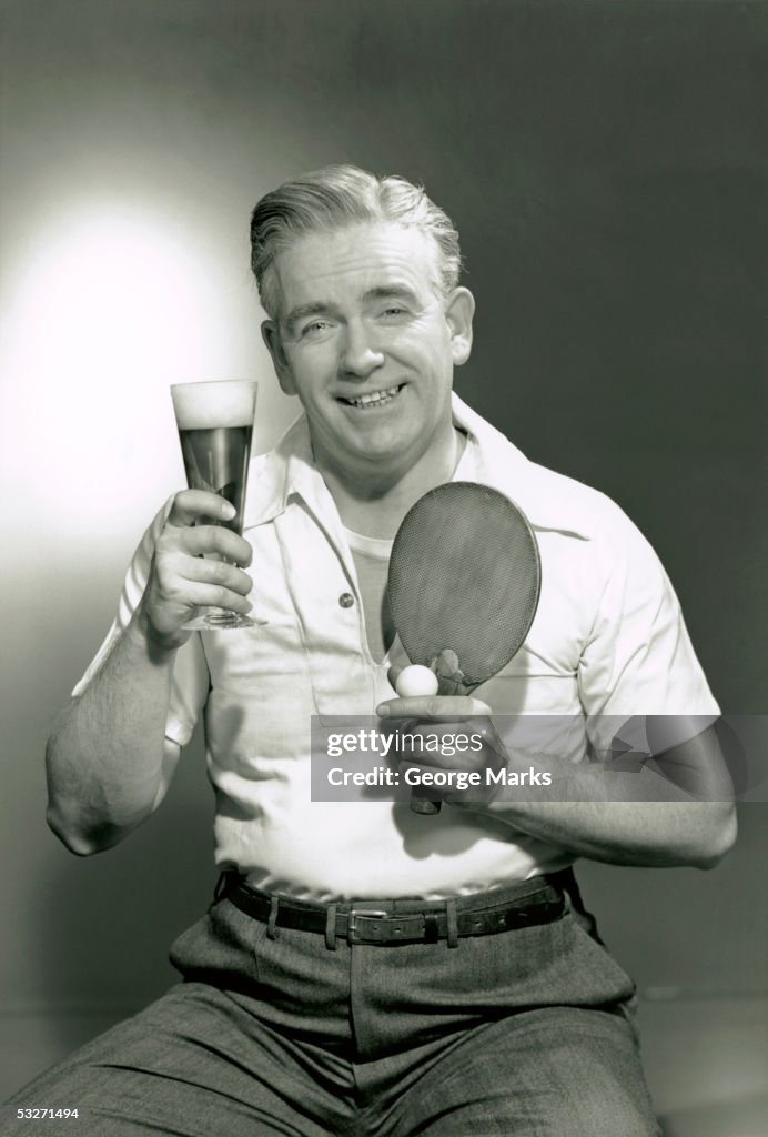 Man holding drink and paddle