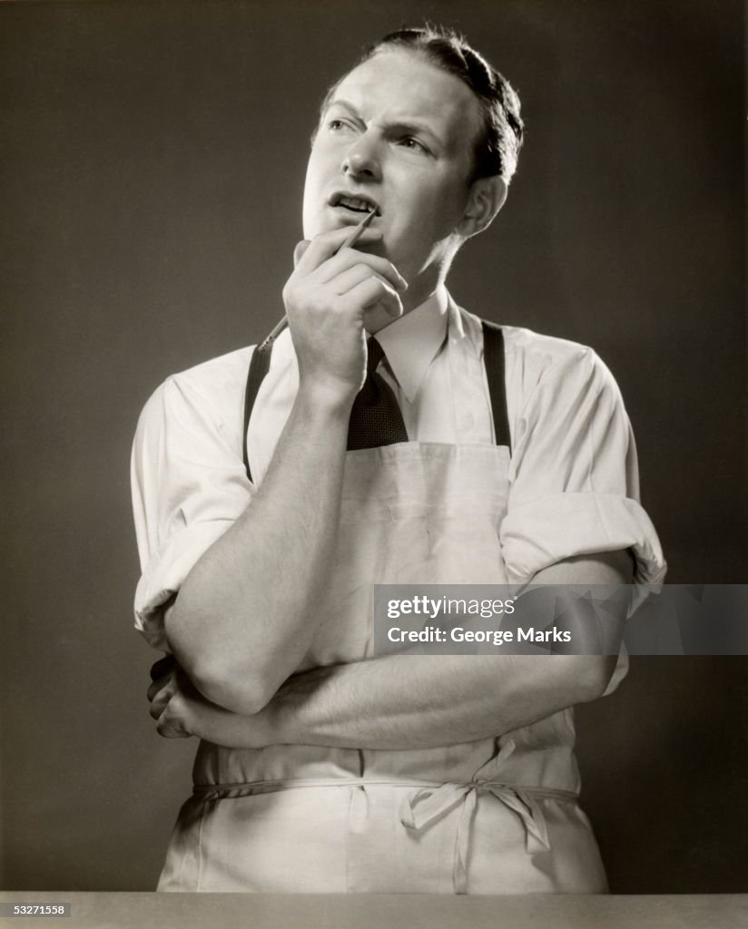 Pondering grocer with pencil in hand