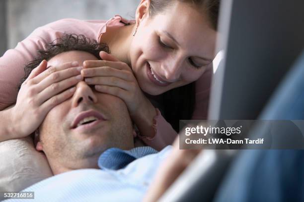 affectionate young couple, woman covering man's eyes - augen zuhalten stock-fotos und bilder