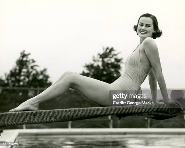 woman in bathing suit seated on diving board - vintage woman diving fotografías e imágenes de stock