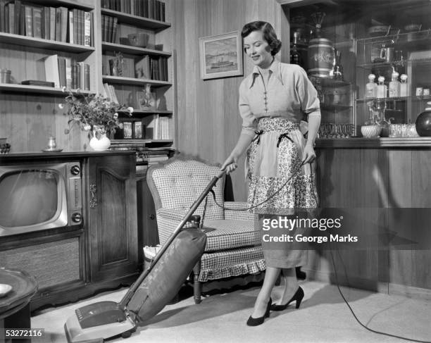 apron housewife vacuuming den - hausfrau stock-fotos und bilder