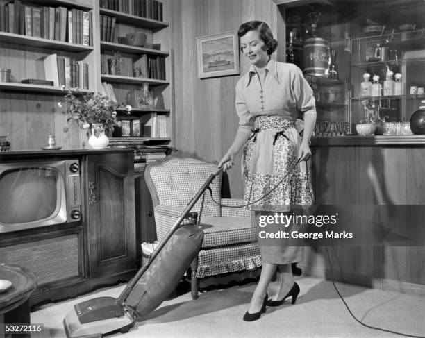 apron housewife vacuuming den - stereotypical foto e immagini stock