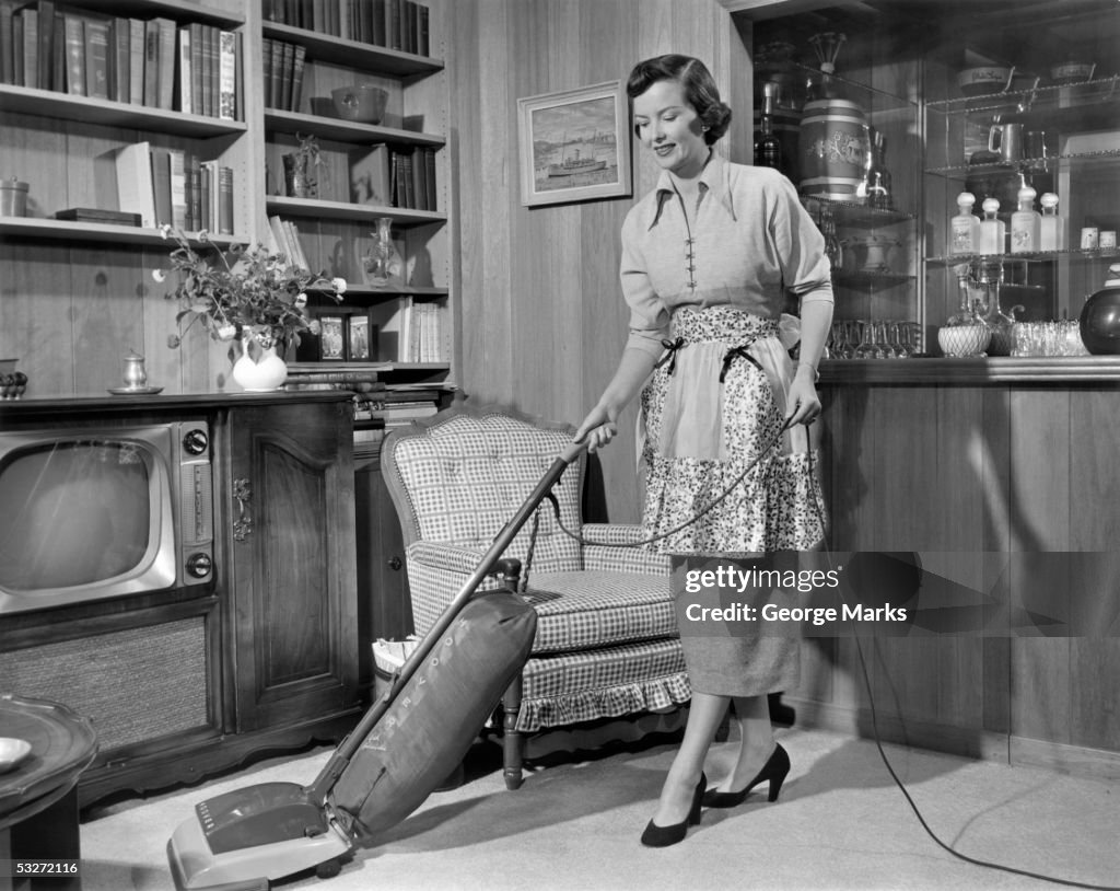 Apron housewife vacuuming den