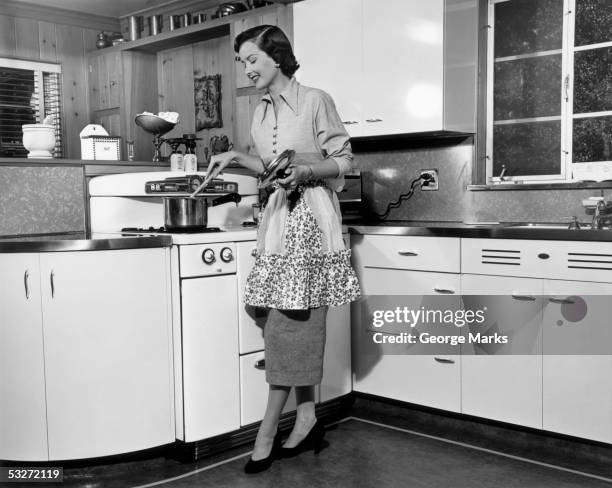 woman stirring pot at stove - madre ama de casa fotografías e imágenes de stock